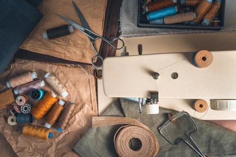 A seamstress's workplace with thread, scissors and a sewing machine. Stock Photos