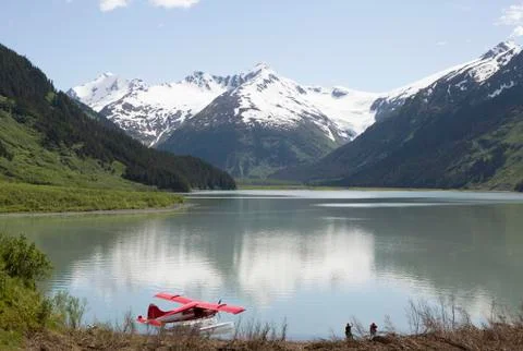 Seaplane docked in still lake in mountain landscape, Anchorage, Alaska, Denali Stock Photos