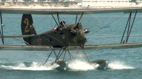 Seaplane U-2 or Po-2 floats like boat toward shore. Seaplane (NATO: "Mule"). Stock Footage 131583727