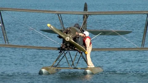Seaplane U-2/Po-2 (Mule) in water with engine turned off. Pilot turns screw. Stock Footage 121168992