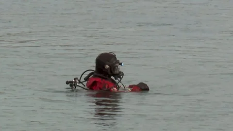 SEARCH AND RESCUE DIVER GOING DOWN INTO THE RIVER Stock Footage