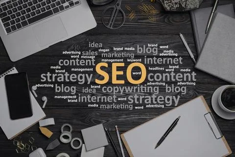 Search engine optimization (SEO). Cloud of words, laptop and stationery on .. Stock Photos