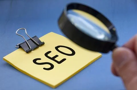 Search Engine Optimization text on sticky note with hand holding magnifying.. 스톡 사진