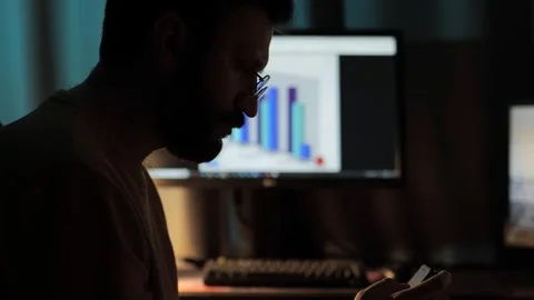 Search for a solution. Silhouette of a man against a computer screen with Stock Footage 306215556