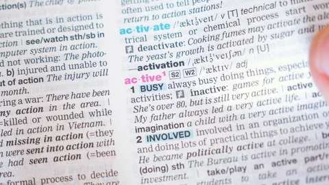 Searching for and finding a word active definition in a dictionary Stock Footage 97924273