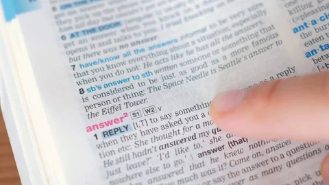 Searching for and finding a word answer definition in a dictionary Stock-Footage 97924570