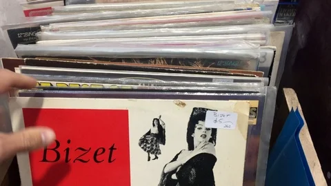 Searching through a stack of second hand vinyl records at an antique store. Stock Footage 107650002