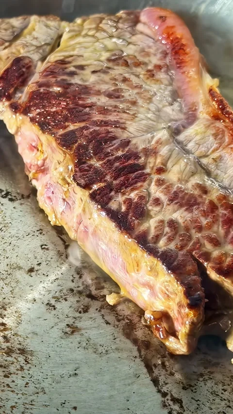 Seared Beef Steak Sizzling on a Hot Grill Pan Stock Footage 336651142