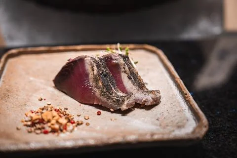Seared tuna slices on rustic stoneware in a luxury Japanese restaurant 写真素材