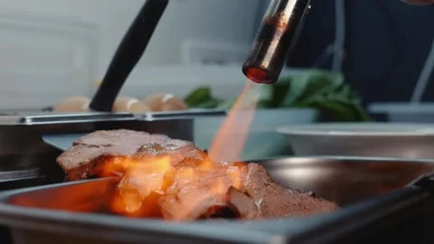 Searing Meat with a Culinary Blowtorch on a Flat Top Grill Stock Footage 340189808