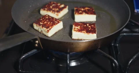 Searing Slices of Halloumi Cheese to a Golden Brown in a Skillet Stock Footage 314856461