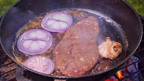 Searing steak with fragrant roasted garlic and slowly cooked onion Stock Footage 326022117