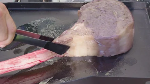 Searing a tomahawk steak outside Stock Footage 287332049