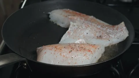Searing white fish fillets in a hot skillet Stock Footage 332620666