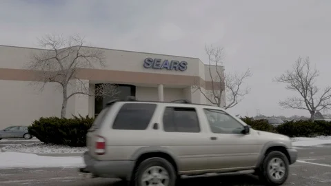 Sears Storefront with Car Passing By Snowing in Colorado Springs, Colorado Video stock 100521331