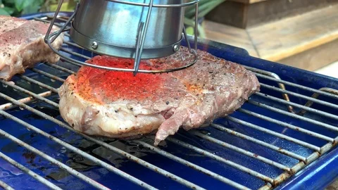 Searzall Torch searing the surfaces of a steak on a grill prior to a bbq Stock Footage 109274459