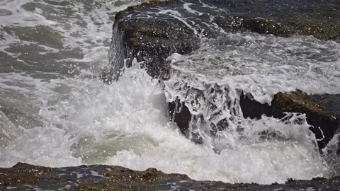 Sea's raw power visualized as turbulent waves meet rocks in slow motion. Stock Footage 249285545