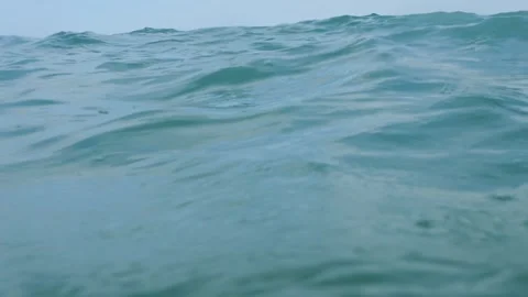 Sea's surface view; camera descends, then emerges, portraying submerged panic 库存影片 255365426