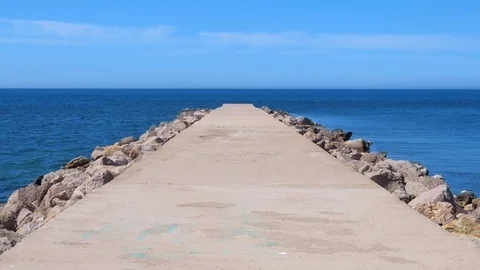 Seascape background with empty long stone pier stretching out to sea sunny day. Stock Footage 116192862
