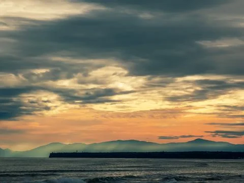 Seascape with cloudy dramatic sky and mountain Stock Photos