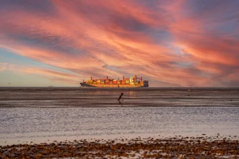  Seascape with dramatic sky, a container ship driving along the horizon Se... Stock Photos