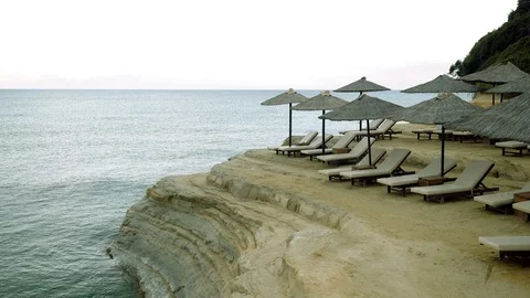 Seascape. Empty sandy beach with sun loungers and umbrellas. Greece. 4K Stock Footage 118076360