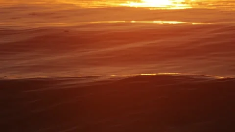 Seascape featuring luminous currents blending with warm orange hues at dusk Stock Footage 321988184