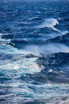 Seascape featuring rows of breaking waves and whitecaps under a clear sky, Ae Stock Photos