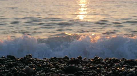 Seascape with orange sky at sunset. Waves beat against the rocky beach Stock Footage 67615801