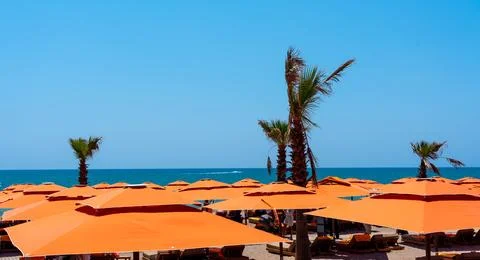Seascape over a solid array of bright orange sun umbrellas Stock Photos