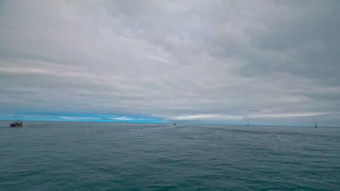 A seascape with overcast sky and tiny yachts in the background.  Stock-Footage 278831419