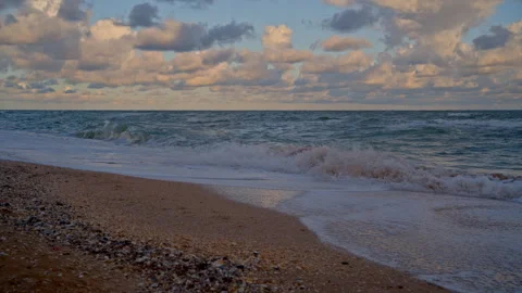 Seascape of Rolling Waves and Cloudy Sunrise on Sandy Beach Stock Footage 318324550