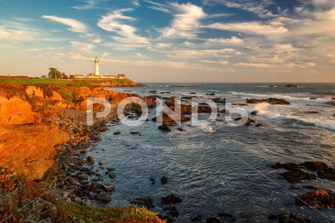 Seascape at sunset. Lighthouse on the coast Stock Photos