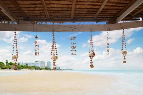 Seashell decoration string under the roof on beach background Stock Illustration