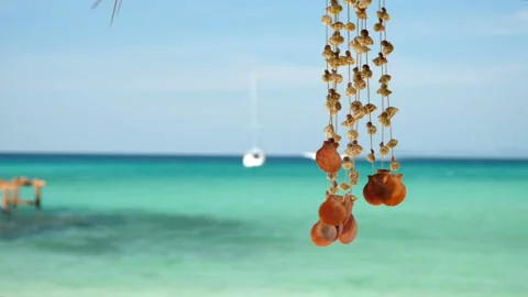 A seashell mobile sways with the wind, on a beautiful  beach of Thailand. Stock Footage 147320443