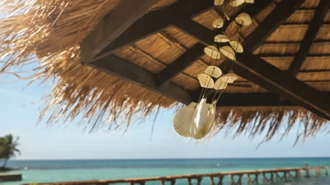 A seashell mobile sways with the wind, on a beautiful  beach of Thailand. Stock Footage 147320597