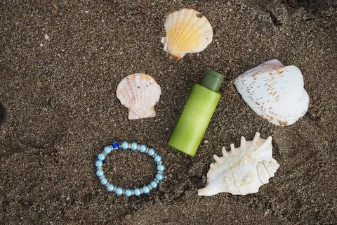 Seashells and bottle on sand at the beach Stock Photos