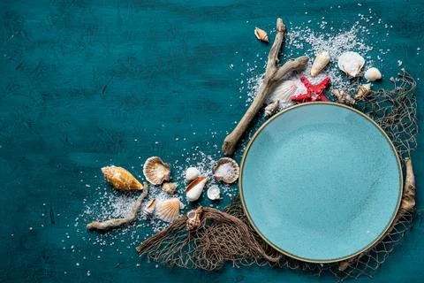 Seashells and coconut shell composition over the bamboo mat against the blue Stock Photos