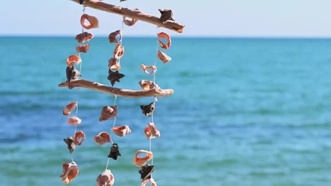 Seashells strung on a rope sway in the wind by the sea, creating their gentle Stock Footage 250857210