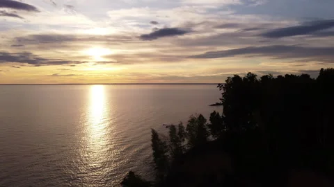 The seashore against the backdrop of the setting sun and beautiful clouds Stock Footage 242392396