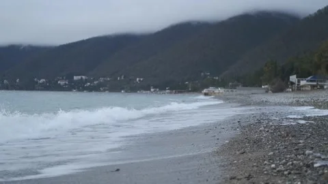 Seashore in cloudy weather against the backdrop of mountains Stock Footage 201054991