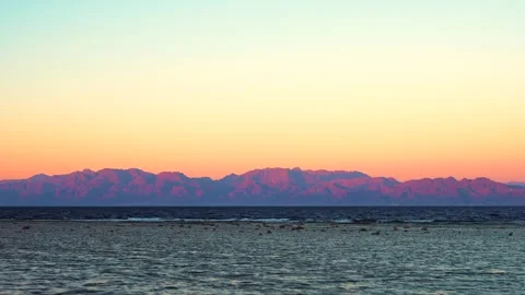 Seashore view of mountain range on the opposite coast with beautiful last pink Vidéo 253209586