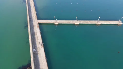 Seaside Harbor Pier Extending Over Calm Turquoise Water Aerial Stock Footage 330105430