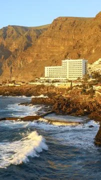 Seaside hotel beneath the dramatic cliffs of Los Gigantes, Tenerife Stock Photos