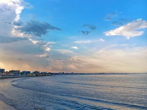 Seaside Landscape with Clouds and Distant Buildings Stock Photos