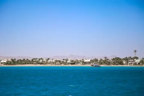 Seaside landscape with still blue water and tropical island. Stock Photos