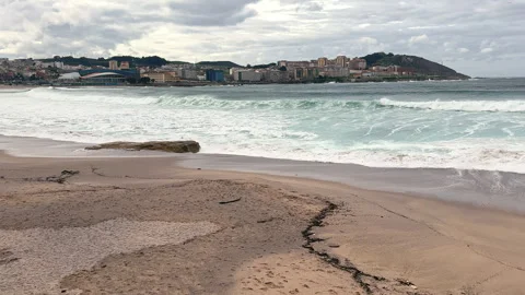 Seaside Serenity: Waves Embrace the Sandy Shores Stock Footage 261767567