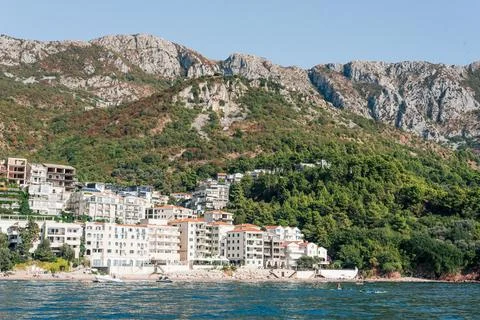 Seaside settlement sits below dramatic limestone cliffs, with modern homes be Stock Photos