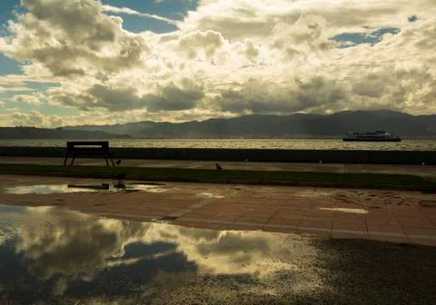 Seaside view after rain. Clouds reflections Stock Photos