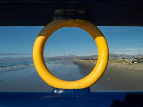 Seaside view framed through the ironwork of New Brighton pier, New Zealand 스톡 사진